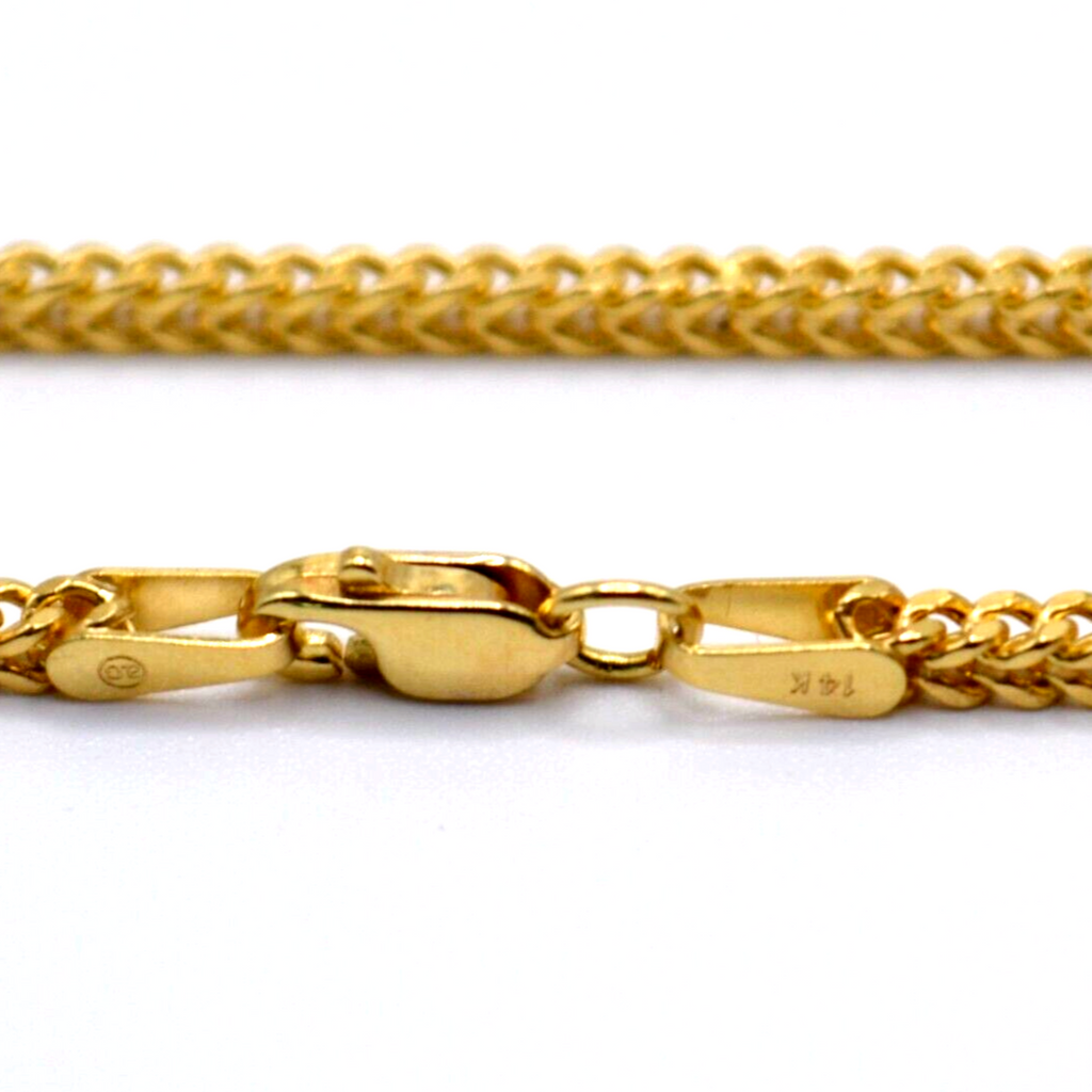 Close-up of lobster clasp on gold bracelet