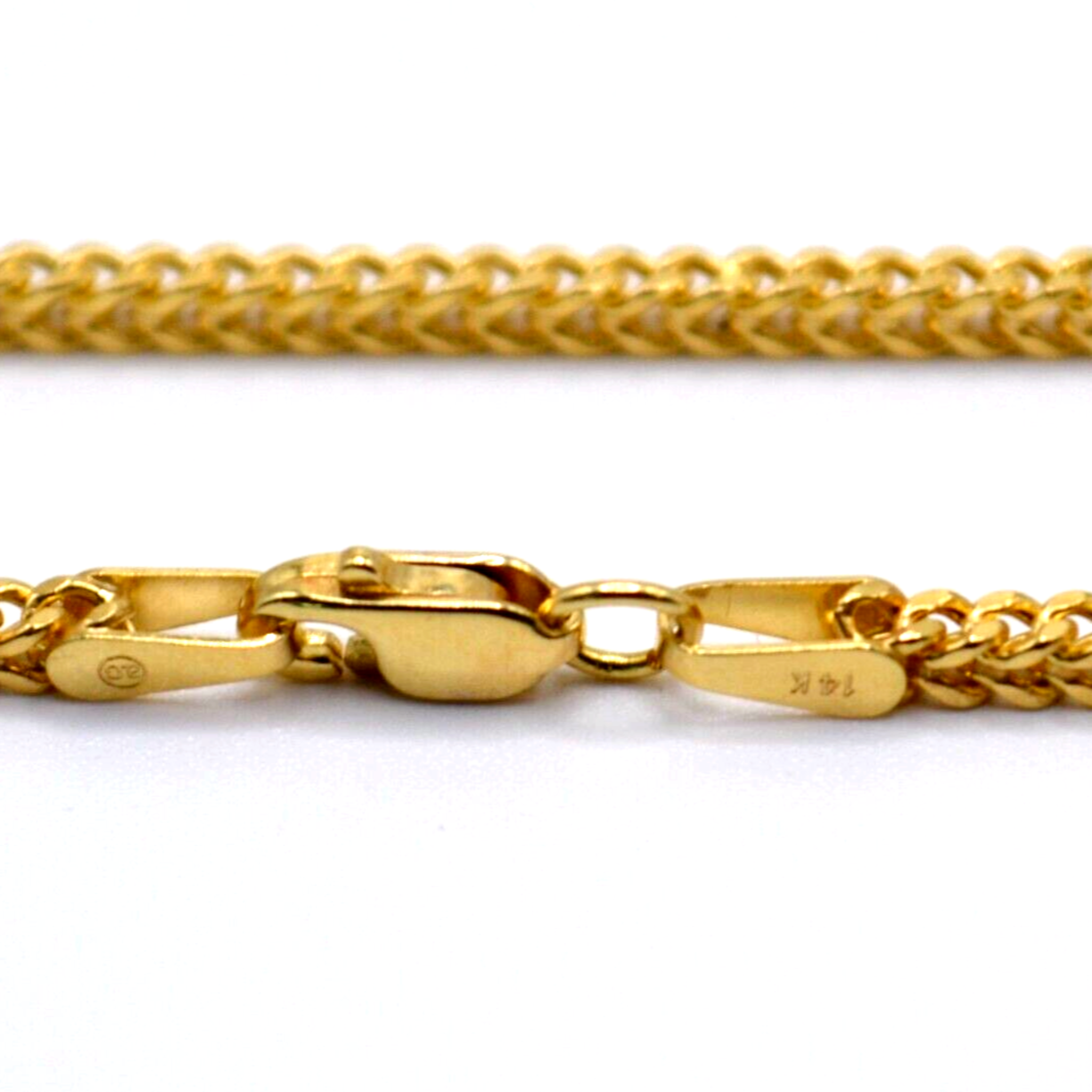 Close-up of lobster clasp on gold bracelet